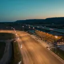 Illustration : une piste de courses attelées et sa tribune sous les projecteurs au crépuscule
